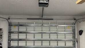 Inside view of a raised garage door showing the horizontal tracks and opener rail