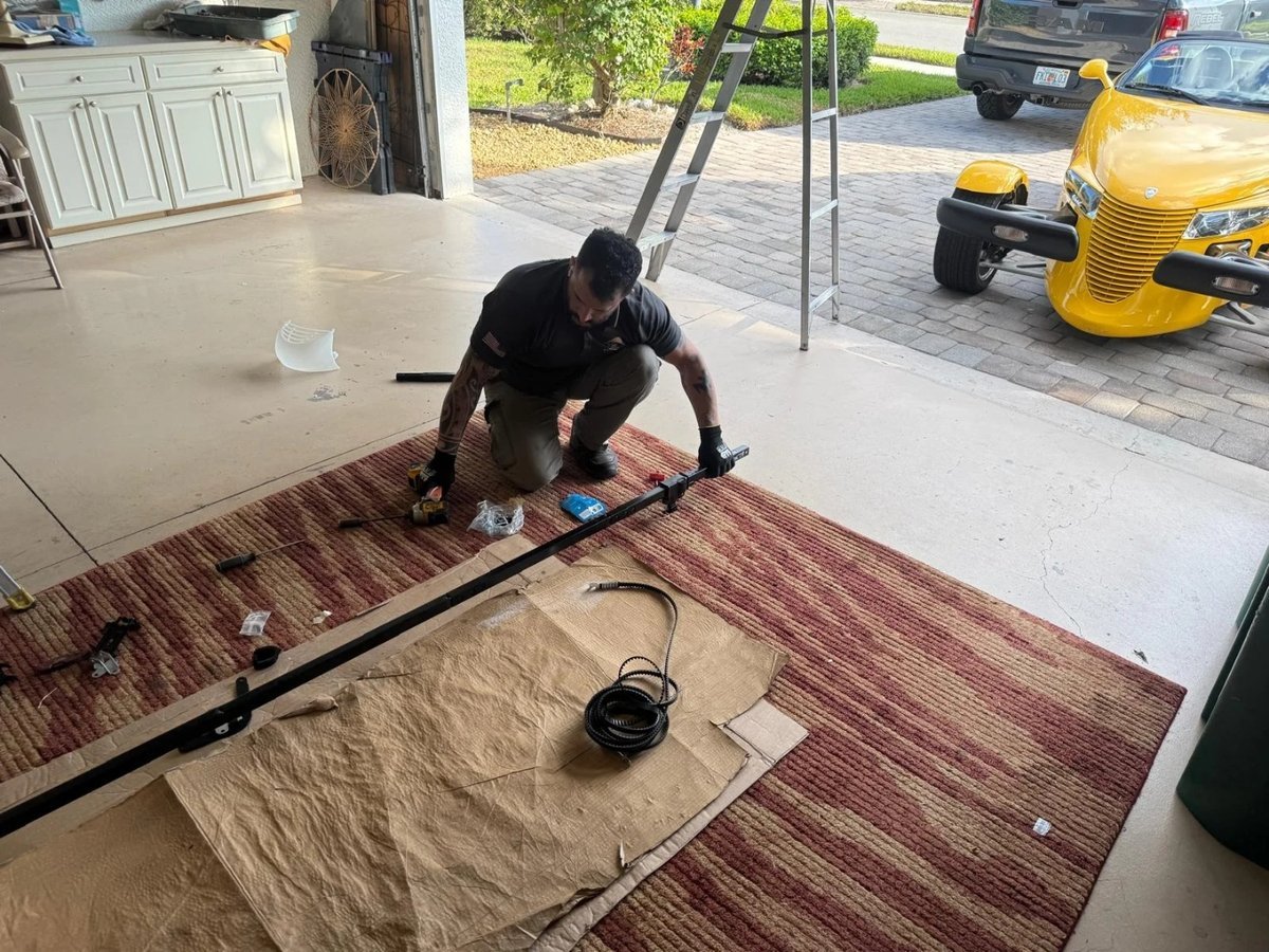 Technician kneeling on a moving blanket while assembling a door section
