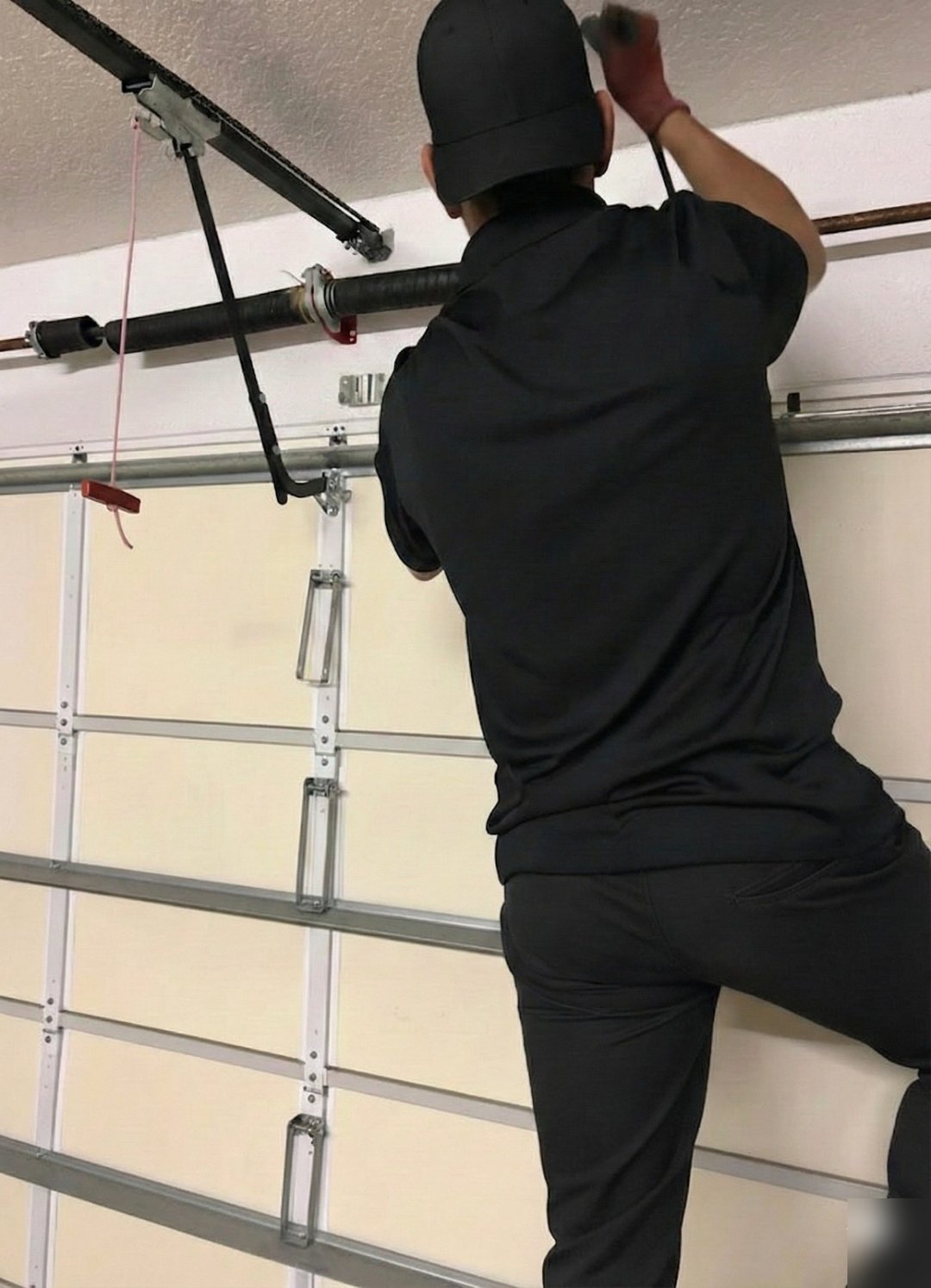 Technician reaching up to a track bracket at the top of a raised-panel door